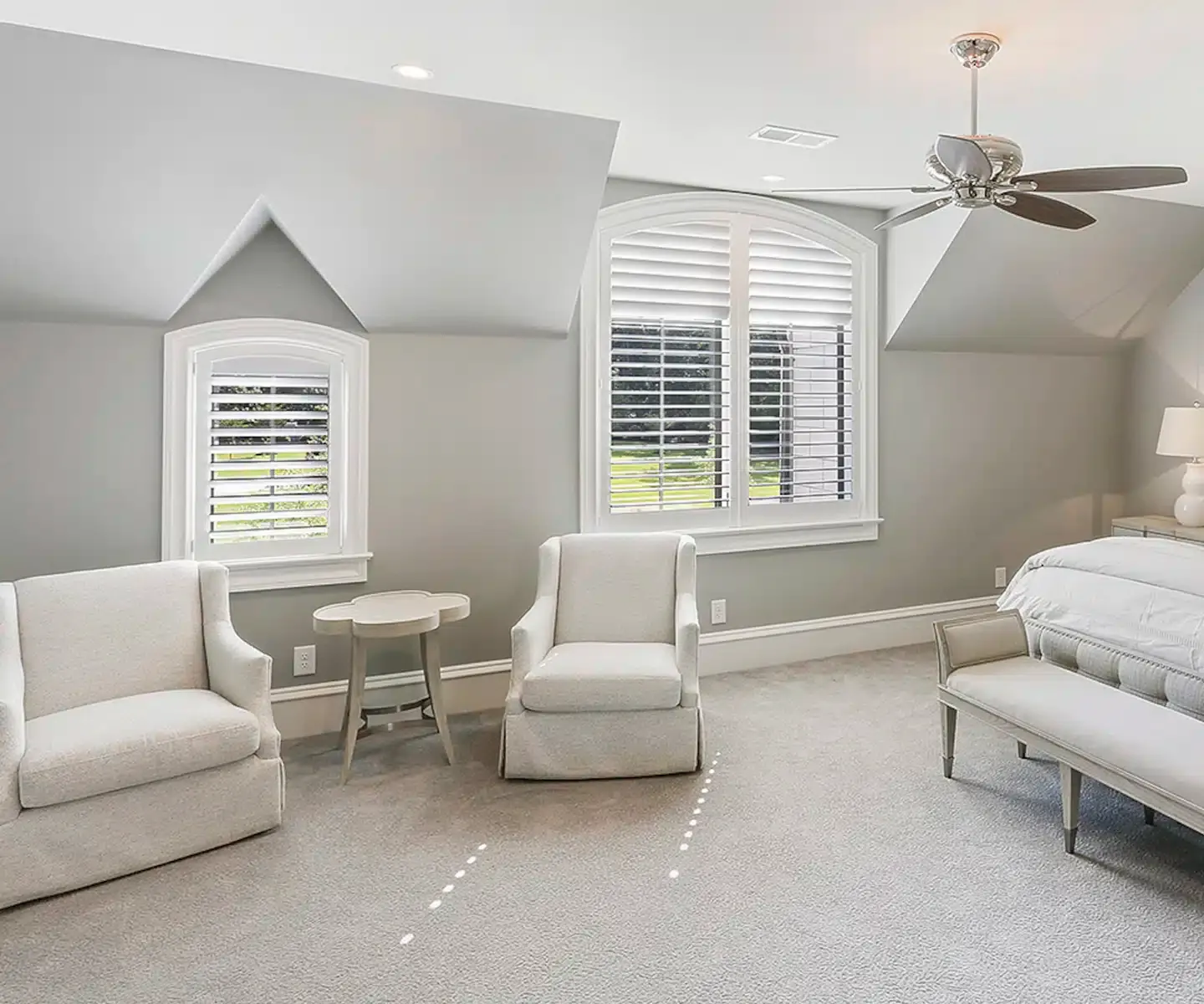 Tall shutters in a bright bedroom sitting area