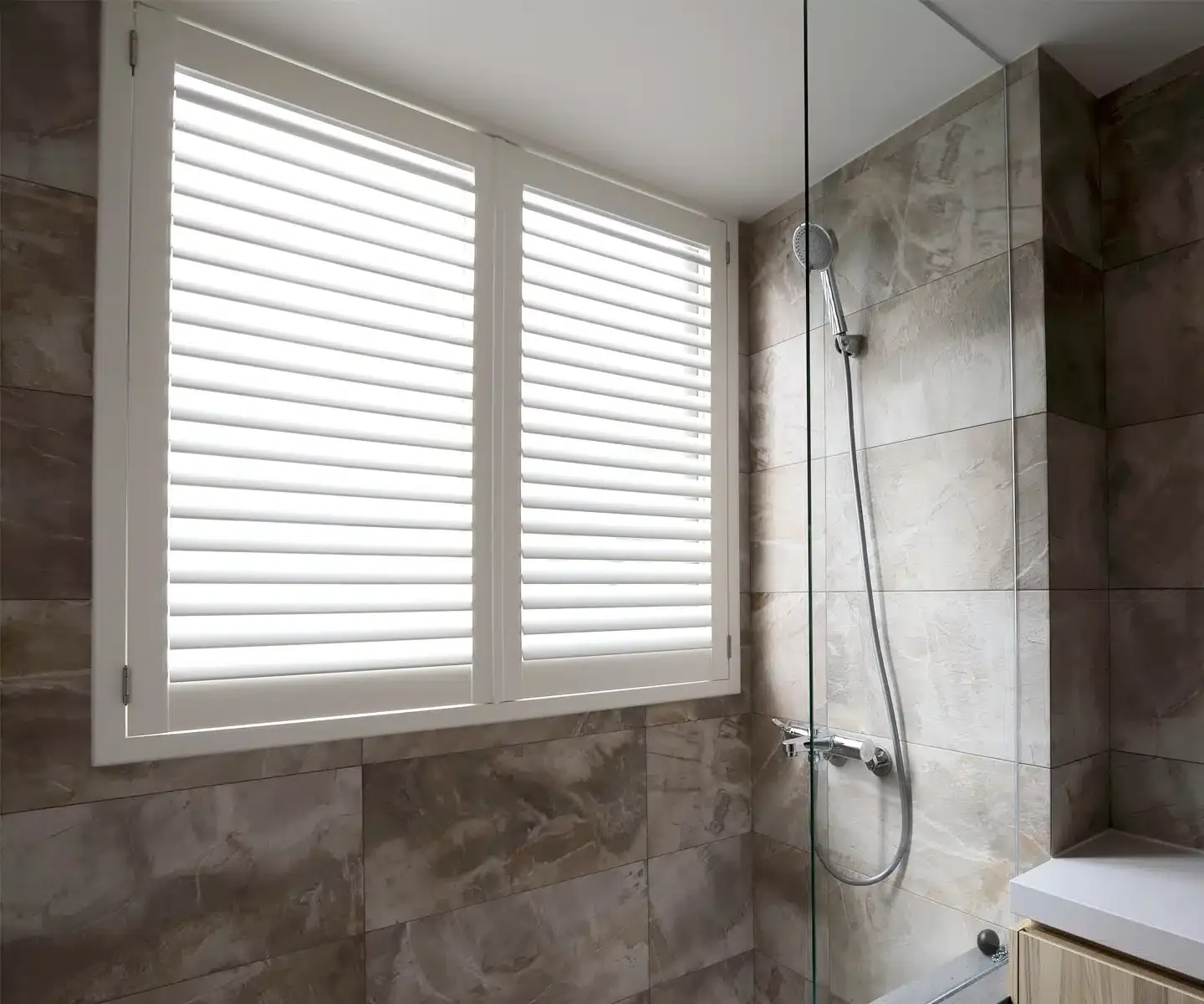 AquaShield waterproof shutters on a window inside a tiled shower